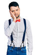 © Krakenimages.com - Hispanic man with beard wearing hipster look with bow tie and suspenders thinking looking tired and bored with depression problems with crossed arms.