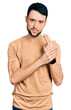 © Krakenimages.com - Hispanic man with beard wearing casual t shirt holding symbolic gun with hand gesture, playing killing shooting weapons, angry face
