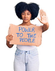 Sticker - Young african american girl holding power to the people banner with open hand doing stop sign with serious and confident expression, defense gesture