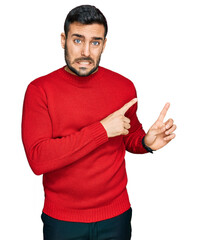 Poster - Young hispanic man wearing casual clothes pointing aside worried and nervous with both hands, concerned and surprised expression