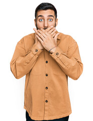 Canvas Print - Young hispanic man wearing casual clothes shocked covering mouth with hands for mistake. secret concept.