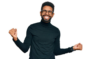 Poster - Young african american man wearing casual clothes very happy and excited doing winner gesture with arms raised, smiling and screaming for success. celebration concept.