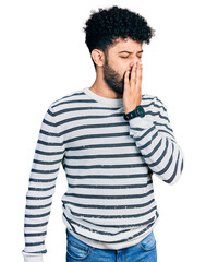 Canvas Print - Young arab man with beard wearing casual striped sweater bored yawning tired covering mouth with hand. restless and sleepiness.