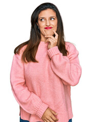 Sticker - Beautiful hispanic woman wearing casual winter sweater serious face thinking about question with hand on chin, thoughtful about confusing idea