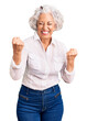 © Krakenimages.com - Senior grey-haired woman wearing casual clothes very happy and excited doing winner gesture with arms raised, smiling and screaming for success. celebration concept.