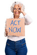 © Krakenimages.com - Senior grey-haired woman holding act now banner smiling happy doing ok sign with hand on eye looking through fingers