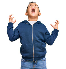 Sticker - Little boy hispanic kid wearing casual sporty jacket crazy and mad shouting and yelling with aggressive expression and arms raised. frustration concept.