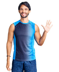 Poster - Handsome hispanic man wearing sportswear showing and pointing up with fingers number five while smiling confident and happy.