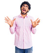© Krakenimages.com - Handsome young man with curly hair and bear wearing business clothes crazy and mad shouting and yelling with aggressive expression and arms raised. frustration concept.