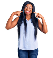 Canvas Print - Young african american woman wearing casual clothes smiling cheerful showing and pointing with fingers teeth and mouth. dental health concept.