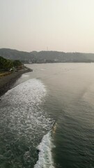 Wall Mural - La Libertad beach in El Salvador low altitude aerial footage as small waves crash ashore.