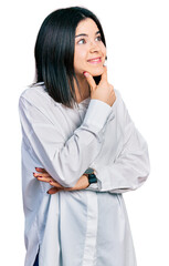 Poster - Young brunette woman with blue eyes wearing oversize white shirt thinking worried about a question, concerned and nervous with hand on chin