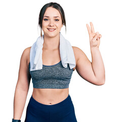 Wall Mural - Young hispanic girl wearing sportswear and towel showing and pointing up with fingers number two while smiling confident and happy.