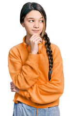 Poster - Young brunette girl with long hair wearing sweatshirt and headphones with hand on chin thinking about question, pensive expression. smiling with thoughtful face. doubt concept.