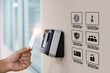 © Eakrin - Hand scanning proximity ID card on reader access control system for door unlock with security icons for identity or verification identify for safety detect fingerprint scan or check attendance.