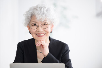 Wall Mural - Computer thinking gray hair smiling face female director, president, chairman, or other executive image of a director, president, chairman, or other executive looking at the camera.