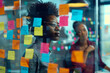 © Nam - a woman standing in front of a glass wall covered in post it notes