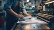 © atipong - Crop image of worker checking print quality of media graphics proof print and color tone in printing industry.