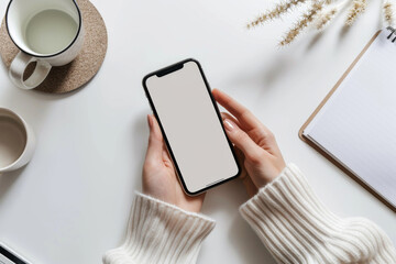 Wall Mural - A woman is holding a cell phone with a white background