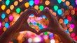 © Muhammad - A close-up shot of hands forming a heart shape against a backdrop of vibrant festival lights