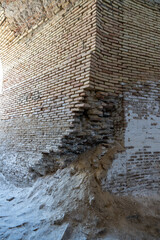 Wall Mural - A brick wall with a hole in it. The wall is made of bricks and has a rough texture