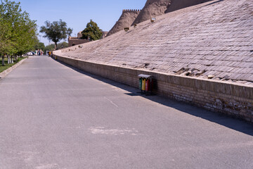 Wall Mural - A street with a brick wall and a trash can