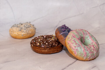 assorted donuts with chocolate frosted, pink glazed and sprinkles donuts.