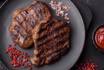 Wall Mural - Fresh juicy delicious beef steak on a dark background