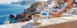 © SERHII - Cup of coffee on a ledge overlooking a beautiful seaside village.