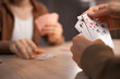 © Andrii Lysenko - Two friends playing cards at home sitting at table, concept of leisure.