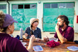 © Marko Geber - Group of farmers enjoying lunch break together outdoors at farm