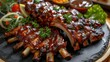 © Tin - Close-up of deliciously glazed, tender barbecue ribs served with fresh vegetables, perfect for any meal or barbecue event.