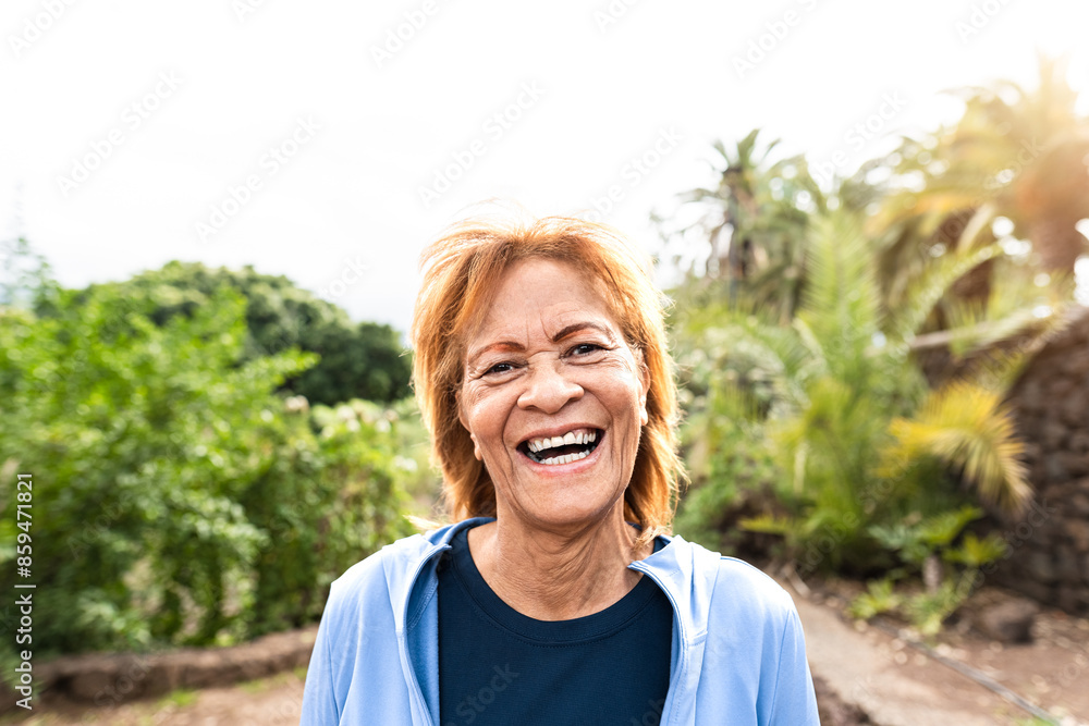 Happy senior Latin woman smiling into the camera while walking in a ...