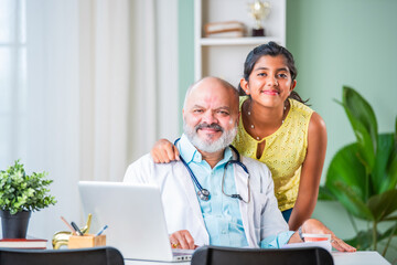 Wall Mural - Portrait of Happy Indian asian girl child patient with senior elderly old male doctor pointing