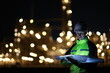 © naraichal - A smart chemical engineer using a digital tablet working late at night with a refinery plant in the background.Engineer working on outdoor building site at night. Engineers working late in power plant