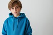 © Iryna - A serious teenage boy in a blue sweatshirt posing in a studio, conveying sadness and introspection.