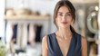 © Sunday Cat Studio - Confident young woman standing in a modern boutique wearing elegant attire, looking at the camera with a slight smile.