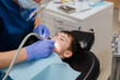 © Ольга Апанасенко - The dentist checks teeth of boy who is sitting in a dental chair. Dental treatment.
