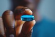 © Sandu - Close-Up of Hand Holding Blue Pill