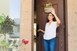 © AntonioDiaz - Smiling homeowner greets one of her neighbors as she opens her front door and leaves her house