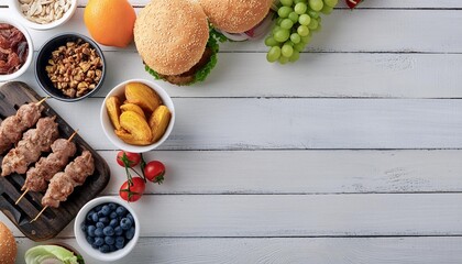 summer bbq food corner border hamburgers meat skewers potatoes fruit and snacks top down view on a white wood banner background copy space
