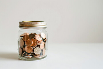 Wall Mural - a jar filled with coins sitting on a table