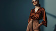 © Generative AI - Portrait of a stylish fashion model girl posing in a designer brown blouse and wide leg pants Gray background Stylish sunglasses Haute couture collection : Generative AI