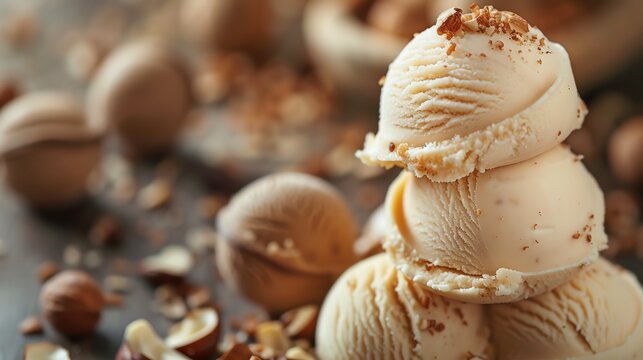 Close-up of a stack of hazelnut ice cream scoops with scattered nuts.