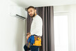 © Angelov - Male technician cleaning air conditioner indoors