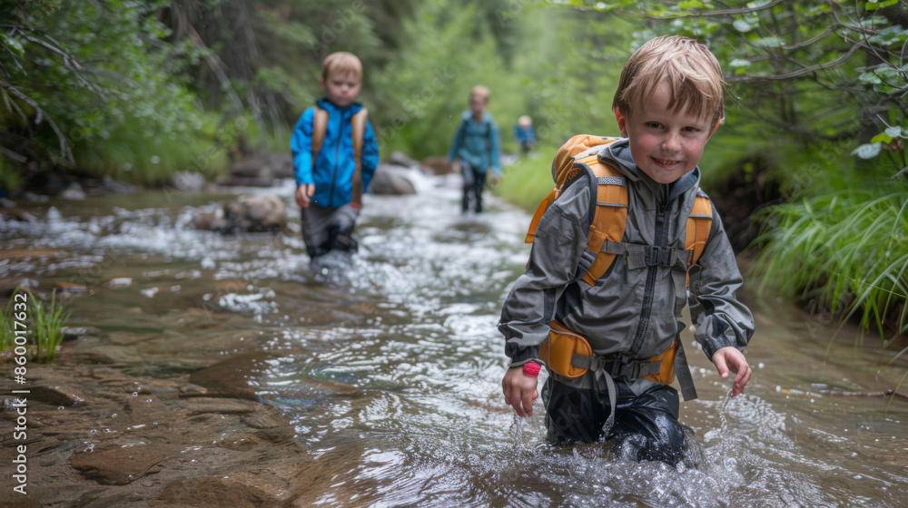 Group of children exploring a shallow stream in the forest, wearing ...