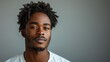 © svastix - An impactful portrait capturing a self-assured young man with natural hair, emanating confidence and calm against a simple, neutral background. Ideal for various themes.