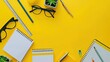 © MiguelAngel - Vibrant workspace with office supplies on yellow background.
