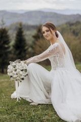 Wall Mural - A bride is sitting on the grass with a bouquet of flowers in her lap. She is wearing a white wedding dress and a veil. The scene is peaceful and serene, with the bride looking content and happy