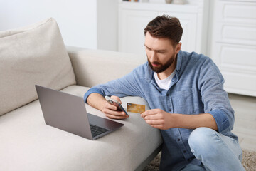 Canvas Print - Online banking. Young man with credit card and laptop paying purchase at home